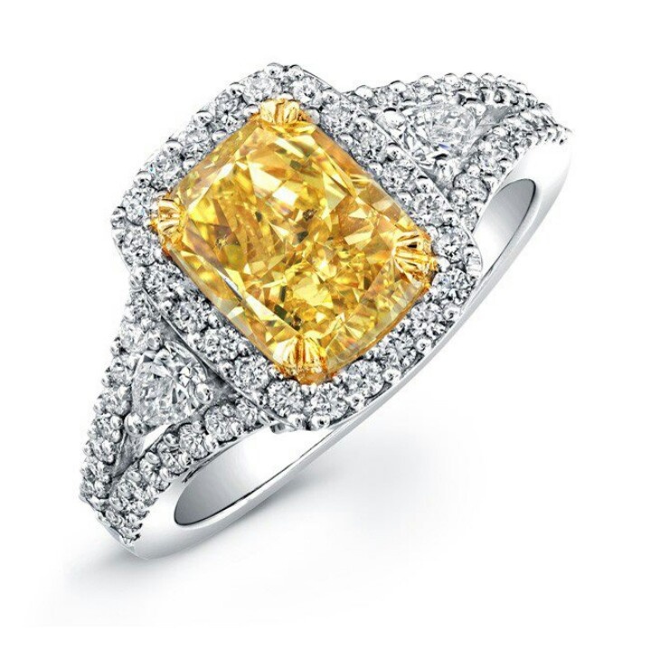 A yellow diamond ring with white diamonds on it's sides.